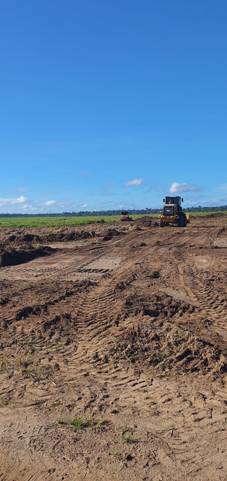 Pá carregadeira espalhando material em serviço de terraplenagem